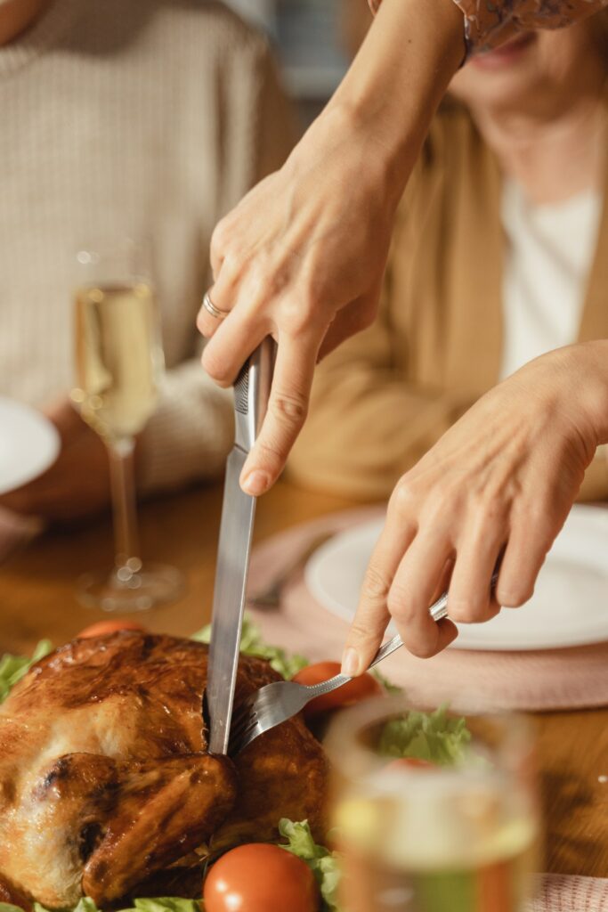 woman cutting a turkey at thansgiving